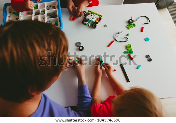 kids and teacher building robot at robotic\
technology school lesson