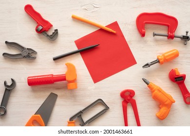 Kids Tool Set And Blank Notebook Paper On White Wooden Background.