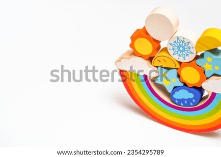 Kids toys. Children's wooden toy in the form of a rainbow. Colorful educational logic wooden toys on white background. Montessori Games. Child Development. Weather. Copy space