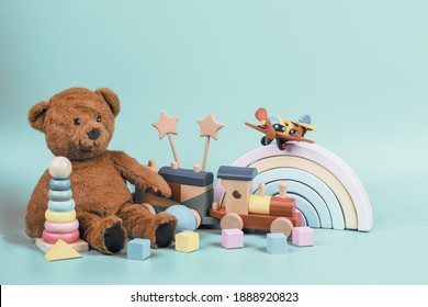 Kids toys collection. Teddy bear, wooden rainbow, train and baby toys on light blue background. Front view - Shutterstock ID 1888920823