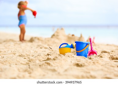 kids toys and little girl building sandcastle - Powered by Shutterstock