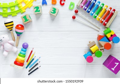 Kids Toys: Pyramid, Wooden Blocks, Xylophone, Train On White Wooden Background. Top View. Flat Lay. Copy Space For Text