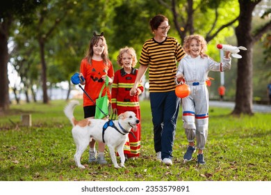 Kids trick or treat in Halloween costume. Children in colorful dress up with candy bucket on suburban street. Little boy and girl trick or treating with pumpkin lantern. Autumn holiday fun. - Powered by Shutterstock