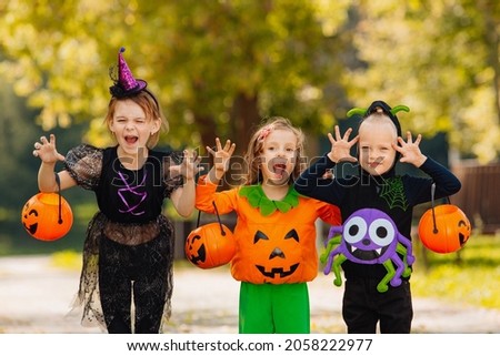 Kids trick or treat in Halloween costume. Happy Halloween. three running kids with a basket for sweets