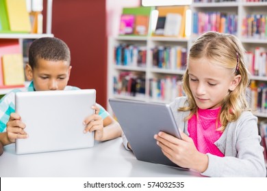 Kids Using Digital Tablet In Library At School