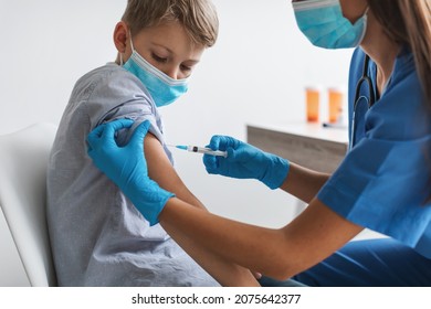 Kids Vaccination. Nurse Injecting Covid-19 Vaccine Vaccinating Boy In Arm For Virus Protection In Clinic. Preteen Child Getting Vaccinated Against Coronavirus Wearing Face Mask. Cropped