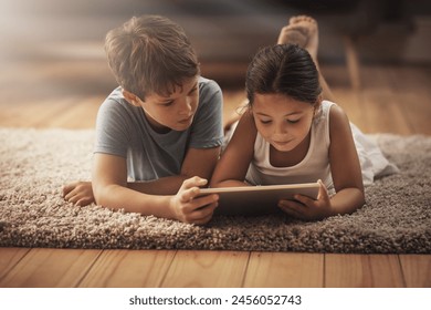 Kids, video and watching with tablet on floor for digital education, ebook and learning in house. Boy, girl and tech on ground for cartoon, children story and video or virtual gaming app in home - Powered by Shutterstock