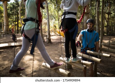 Kids Walking On Rope Bridge In Park On A Sunny Day