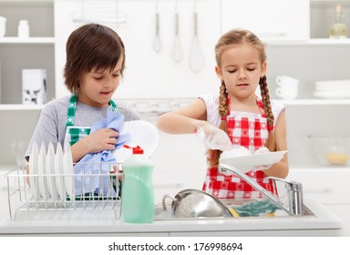 Kids Washing The Dishes In The Kitchen Together - Helping Out With The Home Chores