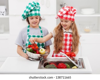 Kids Washing Vegetables In The Kitchen Putting Them In A Strainer