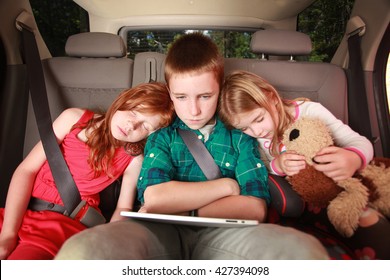 Kids Watching A Movie On A Tablet In The Back Of A Car