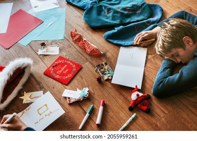 Kids Writing Christmas Cards On Wooden Floor