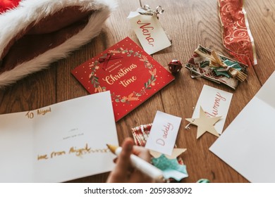 Kids Writing Christmas Cards On Wooden Floor