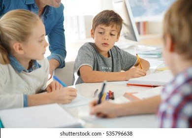 Kids Writing Notes In Classroom