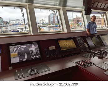 Kiel, Germany 18.6.2022 Captain standing on the captains deck in large boat. Boat interior with screens, radio, radar and navigation
