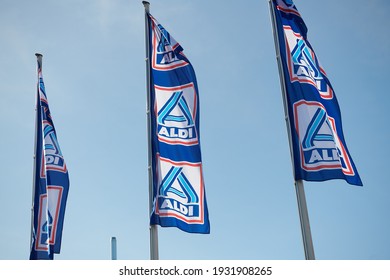 KIEL, Germany - March 08 2021: flags of the discount store ALDI in Kiel, Germany waving in front of a blue sky