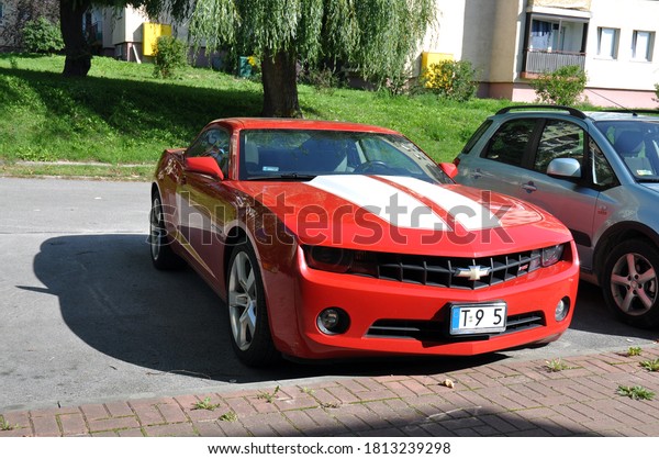 Kielce, Świętokrzyskie / Poland 2020-09-11 Red\
car chevrolet camaro r5 parked in the parking lot by the road (part\
of registration erased)