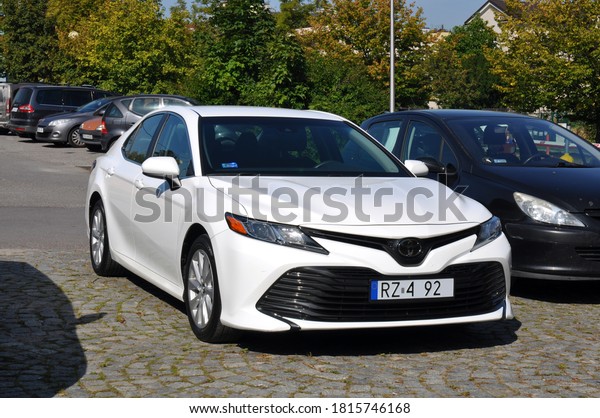 Kielce, Świętokrzyskie / Poland\
2020-09-15 Toyota camry le white car parked in a parking lot in the\
town rear view of the car (part of registration\
erased)