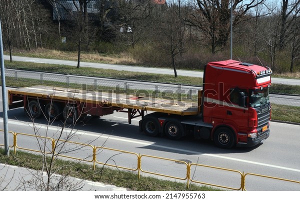 Kielce, Świętokrzyskie, Poland - 2022-04-14 - A
truck with a trailer on the road to transport heavy construction
equipment and machinery