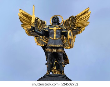 Kiev, Archangel Michael Sculpture at Independence Square. Saint Michael is the patron saint of Ukrainian capital. Gold plated bronze statue isolated against a blue sky.