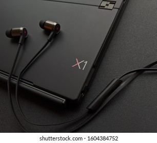 Kiev - July 20 2019: Lenovo ThinkPad X1 In-Ear Headphones And X1 Tablet On The Black Table.