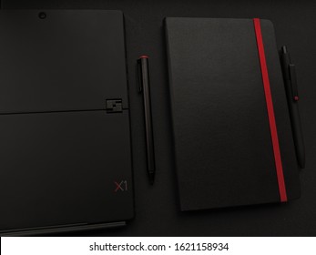 Kiev - July 20 2019: Lenovo Thinkpad X1 Tablet With Moleskine Notebook On The Black Table.