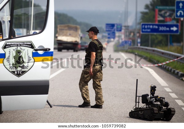 KIEV REGION, UKRAINE - July 26, 2016: Robot of\
explosive technical service of National Police of Ukraine inspect\
the road after an anonymous report on mining of a public transport\
stop in Kiev region.