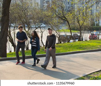 Kiev, Ukraine - 14, April, 2018: two guys and a girl are walking along the street during the day