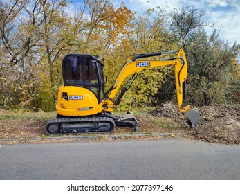 Kiev, Ukraine - 16 October 2021: Modern yellow JCB digger or excavator performs excavation work outdoors