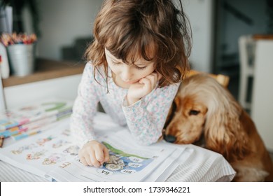 Kiev, Ukraine - 22.05.2020: Cute five years girl learning letters and reading home. Education and distance learning for kids. Homeschooling concept