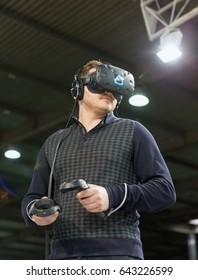 KIEV, UKRAINE - APRIL 07, 2017: Man Use Virtual Reality Game Glasses And Hand Controllers At 2nd International Trade Show Of Electric And Hybrid Vehicles Plug-In Ukraine In KyivExpoPlaza Venue.