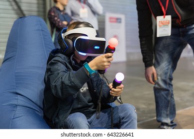 KIEV, UKRAINE - APRIL 07, 2017: Boy Use Virtual Reality Game Glasses And Hand Controllers At 2nd International Trade Show Of Electric And Hybrid Vehicles Plug-In Ukraine In KyivExpoPlaza Venue.