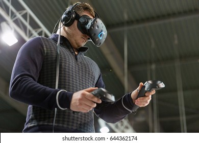 KIEV, UKRAINE - APRIL 07, 2017: Man Use Virtual Reality Game Glasses And Hand Controllers At 2nd International Trade Show Of Electric And Hybrid Vehicles Plug-In Ukraine In KyivExpoPlaza Venue.