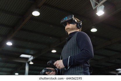 KIEV, UKRAINE - APRIL 07, 2017: Man Use Virtual Reality Game Glasses And Hand Controllers At 2nd International Trade Show Of Electric And Hybrid Vehicles Plug-In Ukraine In KyivExpoPlaza Venue.