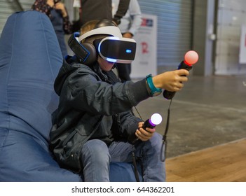 KIEV, UKRAINE - APRIL 07, 2017: Boy Use Virtual Reality Game Glasses And Hand Controllers At 2nd International Trade Show Of Electric And Hybrid Vehicles Plug-In Ukraine In KyivExpoPlaza Venue.