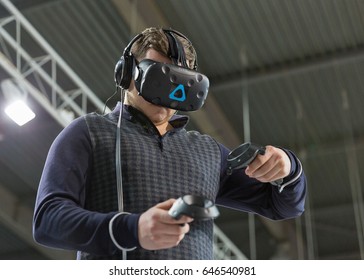 KIEV, UKRAINE - APRIL 07, 2017: Man Use Virtual Reality Game Glasses And Hand Controlers At 2nd International Trade Show Of Electric And Hybrid Vehicles Plug-In Ukraine In KyivExpoPlaza Venue.