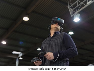 KIEV, UKRAINE - APRIL 07, 2017: Man Use Virtual Reality Game Glasses And Hand Controlers At 2nd International Trade Show Of Electric And Hybrid Vehicles Plug-In Ukraine In KyivExpoPlaza Venue.