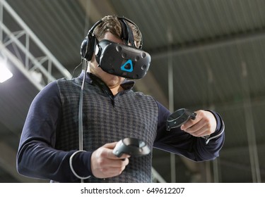 KIEV, UKRAINE - APRIL 07, 2017: Man Use Virtual Reality Game Glasses And Hand Controllers At 2nd International Trade Show Of Electric And Hybrid Vehicles Plug-In Ukraine In KyivExpoPlaza Venue.