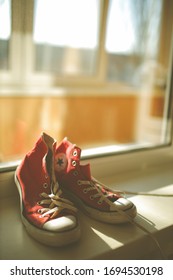 Kiev, Ukraine - April 2, 2020: Red Converse Sneakers. Sneakers. Red Colored Covers Are Near The Window. Vintage Photo Processing.