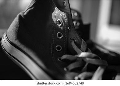 Kiev, Ukraine - April 2, 2020: Red Converse Sneakers. Sneakers. Covers Are Near The Window. Black And White Photo.