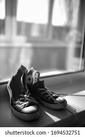 Kiev, Ukraine - April 2, 2020: Red Converse Sneakers. Sneakers. Covers Are Near The Window. Black And White Photo.