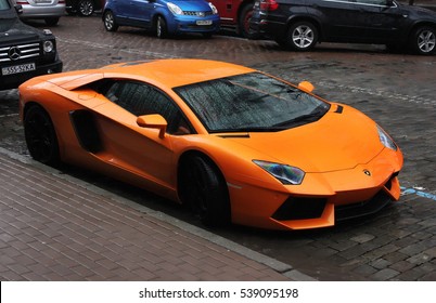 Kiev, Ukraine - April 8, 2012: Orange Lamborghini Aventador in the city. Italian supercar. The car in the rain