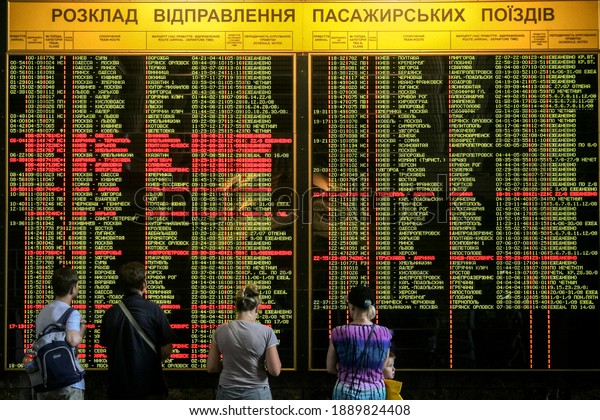 KIEV - UKRAINE - AUGUST 10,\
2014: Passengers looking at the electronic departures and arrivals\
board in the main train station of Kiev, getting ready to\
travel.\
\
