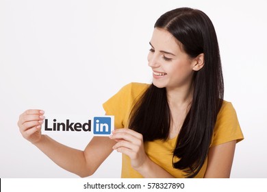 KIEV, UKRAINE - August 22, 2016: Woman hands holding Linkedin logo sign printed on paper on white background. Linkedin is popular a business social networking service.