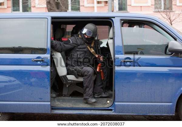 KIEV, UKRAINE -\
FEBRUARY 19, 2014: Kiev center. Armed military special services get\
into a car after dispersing protesters on Independence Square in\
Kiev, February 19, 2014