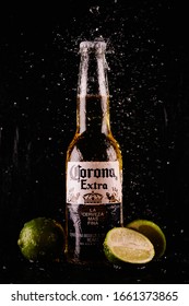 KIEV, UKRAINE - FEBRUARY 25.2020: A Bottle Of Corona Extra Beer With Spray Of Water On A Black Background. Corona Extra Beer Bottle With Lime Slices