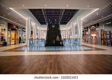 Kiev, Ukraine. January 7, 2021. Modern Shopping Center, Outlet Mall Hall From Inside. Teenage Girl Goes Up Standing On Escalator During Winter Shopping. Fashion Stores Interior. Shopper, Customer