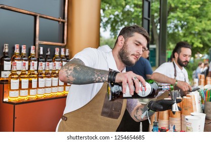 KIEV, UKRAINE - JULY 04, 2018: Young Man Bartender Works In Bacardi Outdoor Bar At The Atlas Weekend Festival In National Expocenter. Bacardi Is The Largest Family Owned Spirits Company In The World.