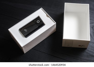 Kiev, Ukraine- July 28, 2019: A box with an electronic device for smoking GLO on a black wooden background. - Shutterstock ID 1464520934