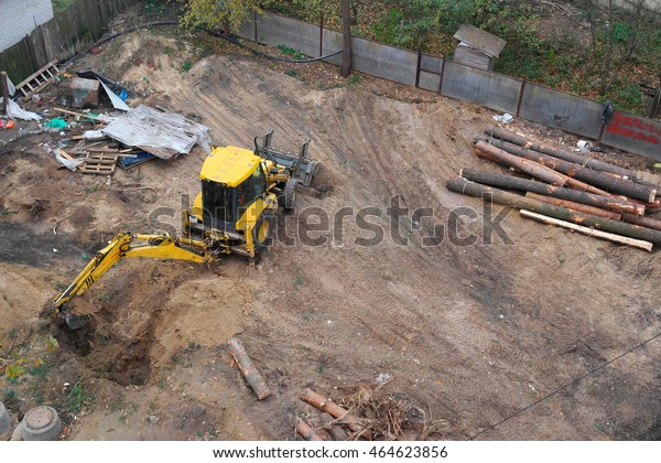 KIEV, UKRAINE - JULY 31, 2016:A backhoe digging\
up some dirt holes in the\
ground.
